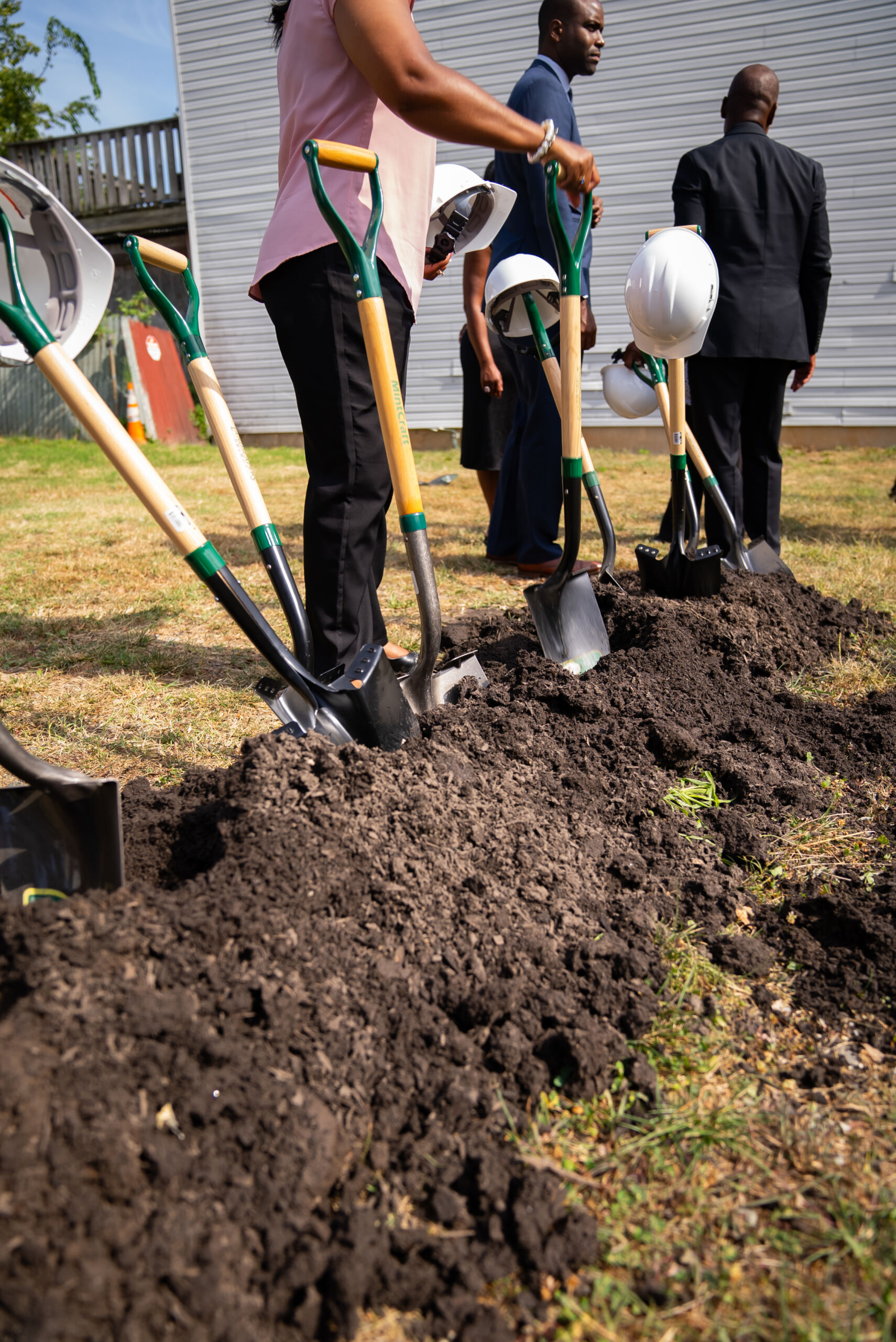 Groundbreaking ceremony with people and shovels.