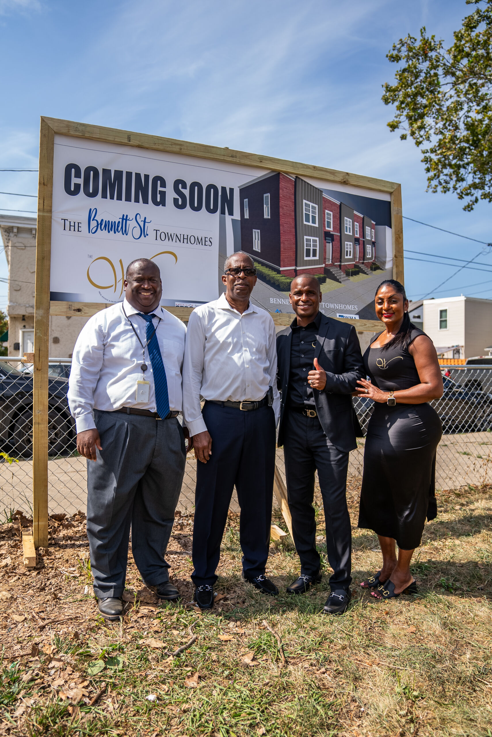Four people in front of construction sign.